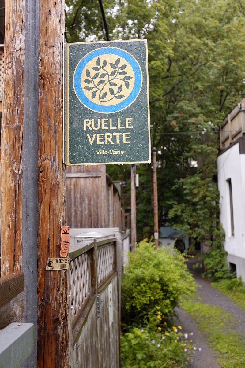 Vue sur une ruelle verte de l’arrondissement de Ville-Marie et logo du réseau des ruelles vertes de Montréal