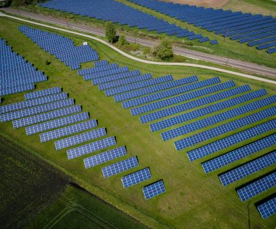 Aerial view of solar panels on a meadow and a road Credit: Andreas Gücklhorn on Unsplash